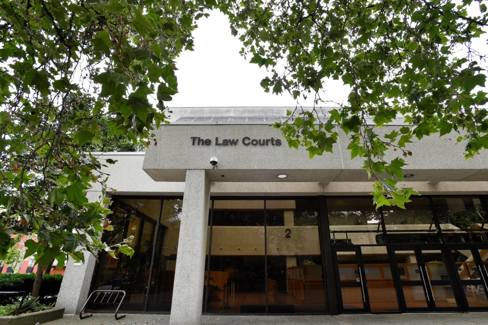 The entrance of the New Westminster Law Courts, framed by tree branches